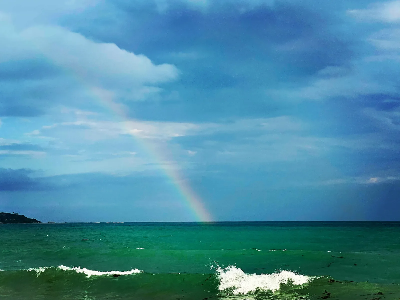 A rainbow over the great sea with waves