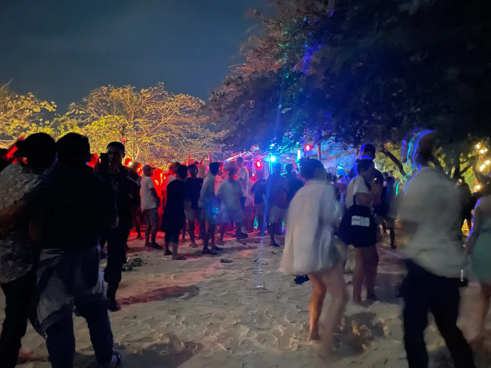 People dancing at a full moon party on a beach