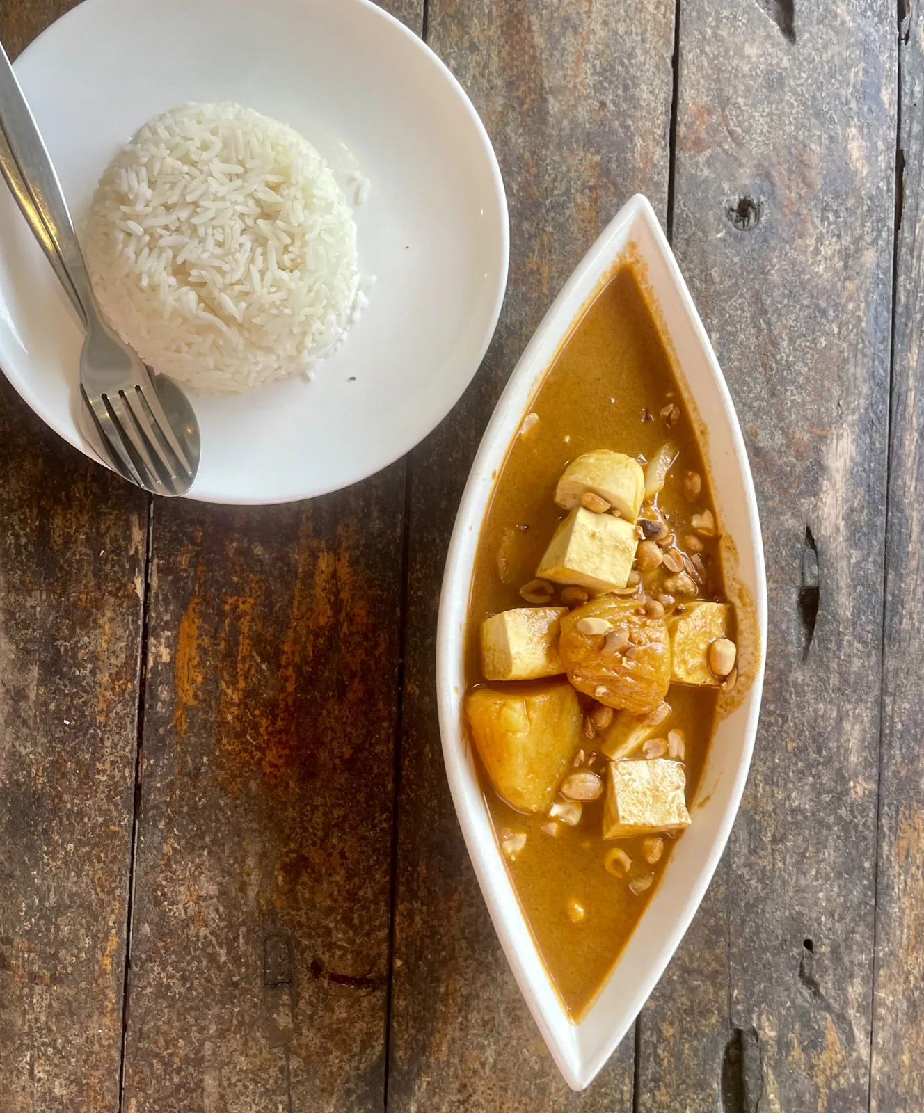 Massaman curry dish with tofu and rice on a White plate