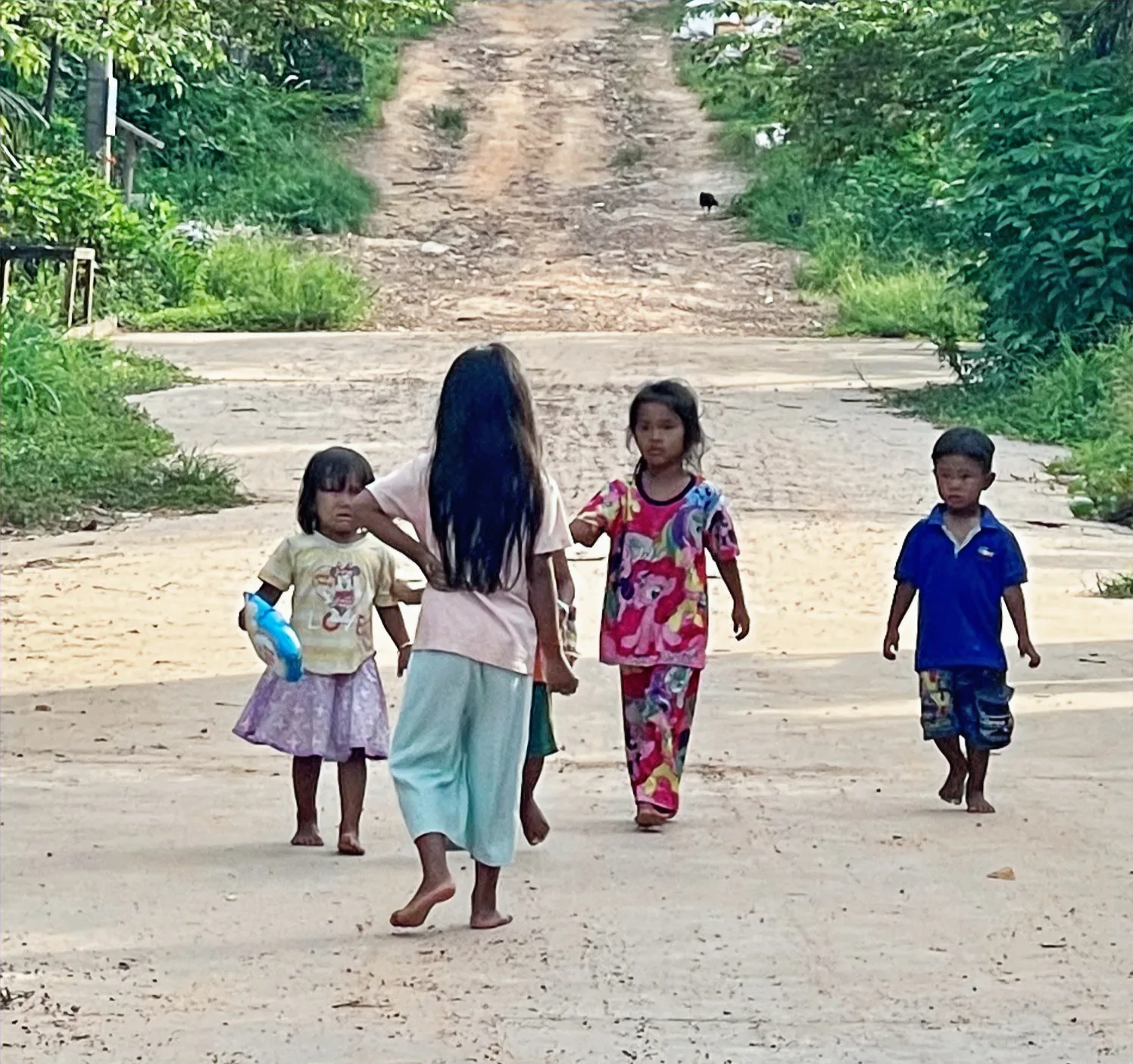 Young children playing on a dirt road in Cambodia