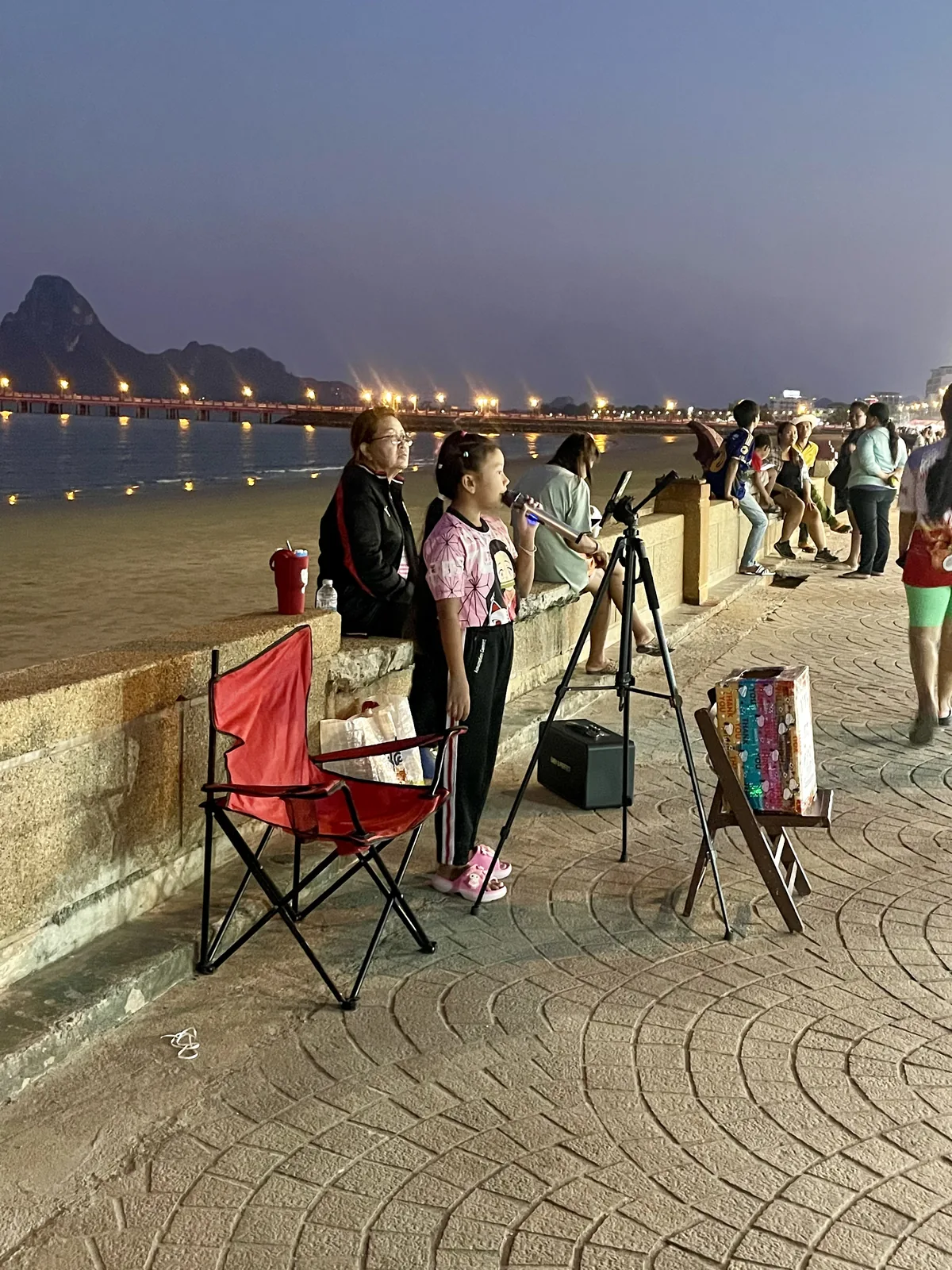 A girl singing on the boardwalk of the Prachuap Khiri Khan night market in Thailand