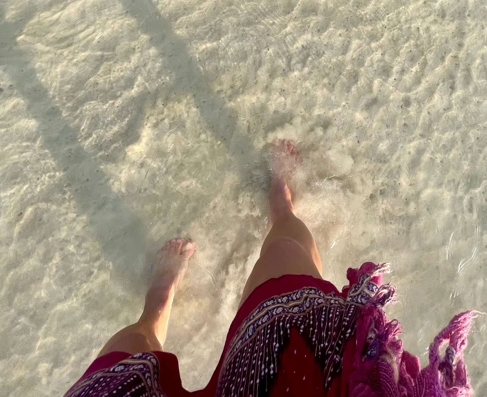 A woman wading barefoot in the ocean in Koh Tao
